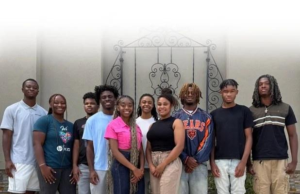 The A Team standing together in front of an iron gate